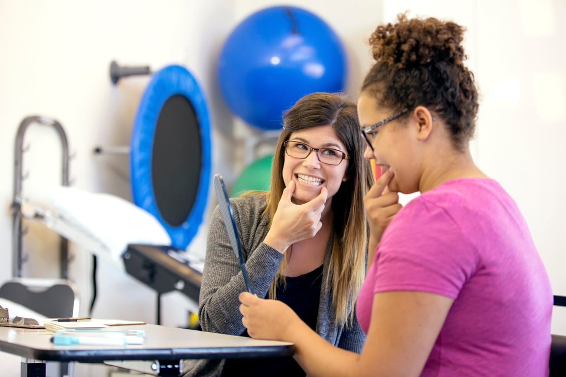 Young adult female therapist doing speech therapy